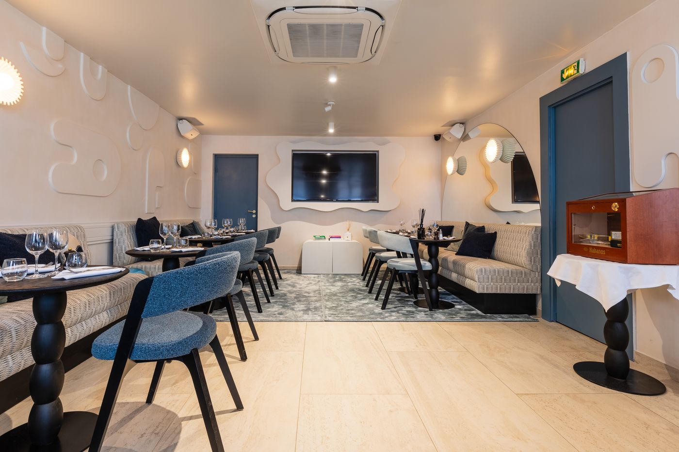 Le salon du fond, salle indépendante avec banquettes, écran et cave à cigares